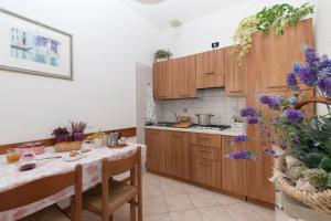 卡瓦利诺Appartamenti Giardino al Mare的厨房配有木制橱柜和紫色花卉桌。