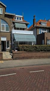 赞德沃特Studio Wijkhuizen的街上有绿色和白色遮阳篷的房子
