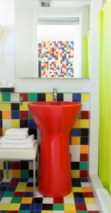 德尼亚维拉莫尔酒店的浴室设有红色水槽和色彩缤纷的地板。