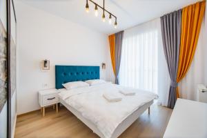 奥拉迪亚Panorama Views - Spacious Central Apartment的卧室配有一张白色的大床和蓝色床头板