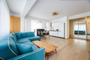 奥拉迪亚Panorama Views - Spacious Central Apartment的客厅配有蓝色的沙发和桌子