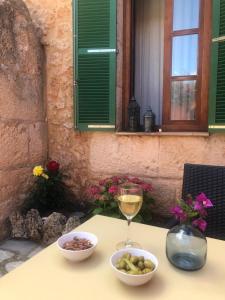 阿尔盖达PETIT HOTEL ALGAIDA的一张桌子,上面放着两碗食物和一杯葡萄酒