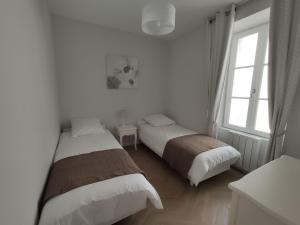 阿姆博斯Les Charmilles的配有2张床的白色墙壁和窗户。
