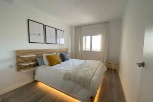 萨洛AMPLIO APARTAMENTO SEAVIEW的卧室设有一张白色大床和一扇窗户。