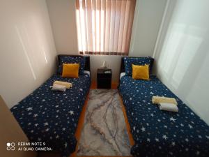 索科矿泉村Apartman Sunce的小客房内的两张床,配有黄色枕头