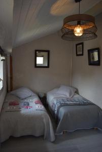 NoilhanMaison de charme dans le Gers的一间卧室配有两张床和吊灯。