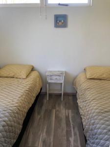 奥德多普Vakantiehuisje in Ouddorp dichtbij het strand的配有两张床铺的客房设有一张边桌