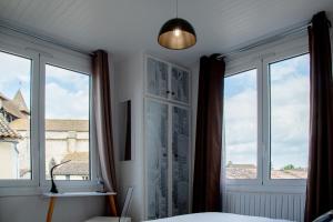 维勒雷阿勒Hôtel & Gastronomie - La Table de l'Europe的卧室设有窗户、一张床和一盏灯。