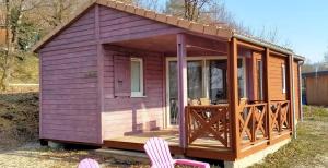 La Chapelle-Aubareil迷人乡村假日公园的紫色的小房子,设有门廊和两把椅子