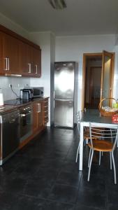 大里贝拉106 Green North的厨房配有桌子和不锈钢冰箱。