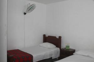 麦德林Hospedaje Primavera的卧室配有两张床,墙上配有风扇