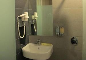 士姑来奥斯汀天堂酒店 - 塔曼蒲莱万达的一间带水槽和镜子的浴室