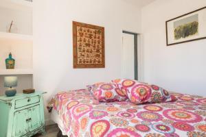 科拉雷侯Casa Agua的卧室内的一张带色彩缤纷的被子和枕头的床
