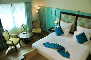 卡拉奇The Reserve Boutique Hotel的一间卧室配有一张大床和蓝色床头板