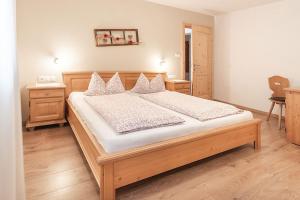 瓦尔奥纳的圣乔凡尼Apartments Silva Alpenblick的一间卧室配有一张大木床和白色床单