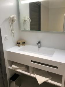 利勒鲁斯Hôtel L'Isula Marina的浴室设有白色水槽和镜子