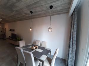 埃尔哥茨拉QLiving Central New Apartments Gzira Sliema Promenade的用餐室配有桌椅和灯