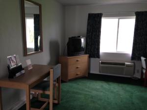 拉法叶经济汽车旅馆 - 拉斐特的客厅配有书桌、电视和窗户。