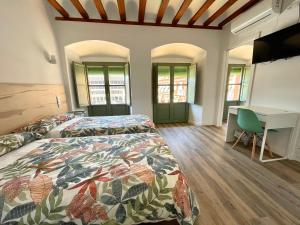 科尔多瓦La Despensa de la Corredera Hostal的一间卧室配有两张床和一张书桌