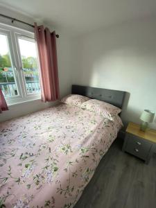 卡纳芬92 Lake View的一间卧室配有一张带粉红色棉被的床和窗户