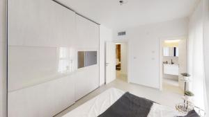 海法Luxury 3&4 Bedroom new apartments - close to the Beach & Bahai Gardens的客厅设有白色的墙壁和大镜子