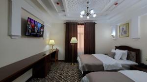 撒马尔罕Hotel Maroqanda的酒店客房设有两张床和电视。