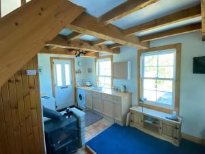 拉姆拉什Lamlash- Self catering accommodation with seaviews的一间铺有蓝色地毯并配有木梁的大厨房