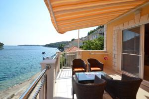 普利兹巴Apartments Korčula的阳台配有桌椅,享有水景。