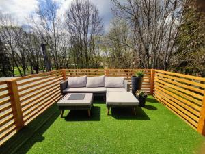 日利纳Apartman Loggia Park & Free Parking的草上带沙发和桌子的庭院