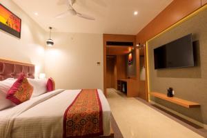 贾姆讷格尔Lords Eco Inn Jamnagar的一间卧室配有一张床和一台平面电视