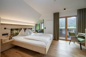魏森湖Hotel Winkler-Tuschnig的一间卧室设有一张大床和一个大窗户