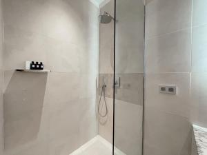 瓦朗斯皮克住宅酒店的浴室里设有玻璃门淋浴