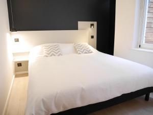 里尔查韦多特公寓的卧室内的一张大白色床,带有窗户