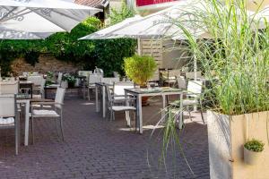 Wasserliesch斯基茨酒店及餐厅的室外餐厅设有桌椅和遮阳伞。