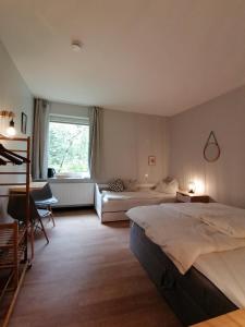 尤尔森Waldjugendherberge Uelsen的一间卧室设有两张床、一张沙发和一个窗口