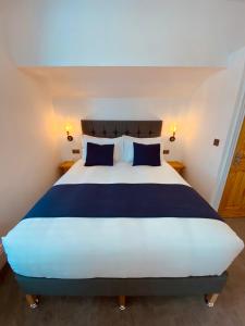 韦茅斯Self Contained Guest suite 2 - Weymouth的一间卧室配有一张带蓝色枕头的大床