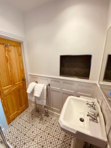 韦茅斯Self Contained Guest suite 2 - Weymouth的一间带水槽的浴室和墙上的电视