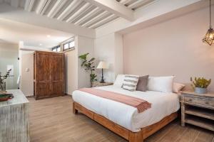 圣米格尔-德阿连德Casa Pandurata Luxury Apartments in Centro, San Miguel de Allende的一间卧室配有一张大床和一张木桌