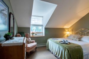 Hastings黑斯廷斯之家住宿加早餐旅馆的卧室配有床、椅子和窗户。