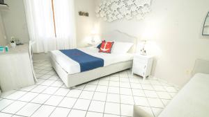 Chiessi伊尔佩赛奥酒店的白色卧室设有床铺和白色瓷砖地板