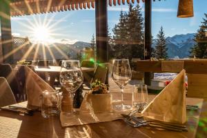卢松Oberhauser Hütte Rodenecker - Lüsner Alm的配有酒杯的桌子,享有山脉美景