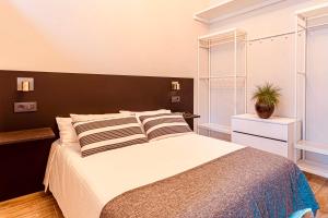 拉科鲁尼亚Downtown Plaza的一间卧室配有一张大床和黑色床头板