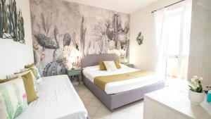 Chiessi伊尔佩赛奥酒店的一间卧室配有两张床和壁画