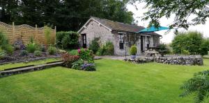阿尔弗斯顿Lile Cottage at Gleaston Water Mill的一座小房子,带草坪四柱形围栏的院子