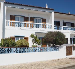 萨格里什Casa Boa Onda的白色的房子,设有蓝色的阳台和植物