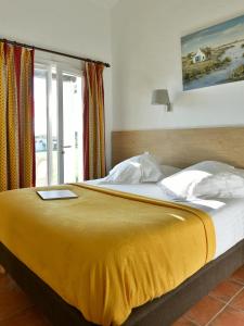 圣马迪拉莫Mas de la Grenouillère Hôtel et Centre équestre en pleine nature的一张带黄色毯子和窗户的床