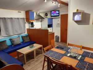 拉波勒Location mobil home的客厅配有蓝色的沙发和桌子