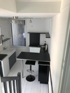 迪纳尔Studio centre Dinard的一个带黑色柜台和水槽的小厨房