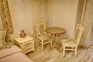 第比利斯古老的第比利斯之门宾馆的一间卧室配有桌子、两把椅子和一张桌子