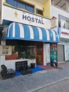 巴克里索莫雷诺港Hostal La Casa de Luis的一座有蓝色和白色遮阳篷的医院大楼